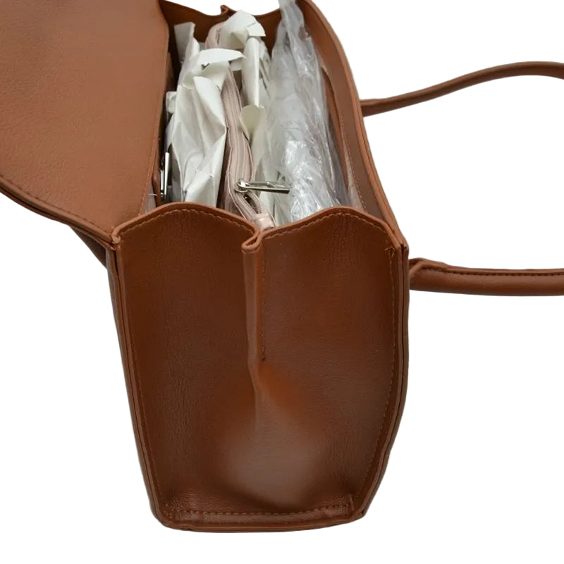 A brown leather tote bag shown open, revealing white tissue paper and clear plastic wrapping inside, on a plain white background.